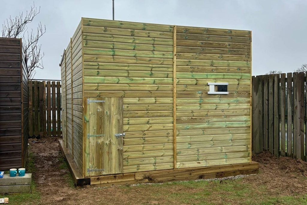 Large walk-in outdoor bird aviary built from timber and mesh
